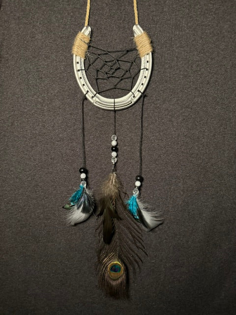 Handmade horseshoe dreamcatcher with black web, turquoise feathers and peacock feather