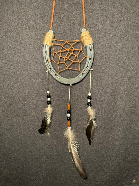 Handmade horseshoe dreamcatcher with orange web, black beads and natural feathers