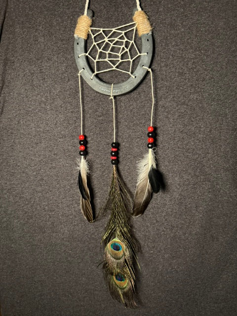 Handmade horseshoe dreamcatcher with white web, red and black beads and peacock feathers