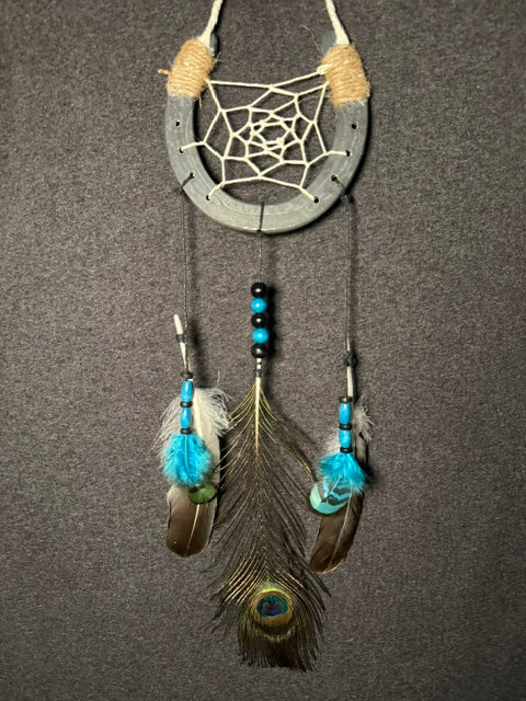 Handmade horseshoe dreamcatcher with white web, turquoise beads and peacock feather