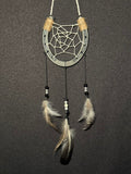 Handmade horseshoe dreamcatcher with white web, black and white beads and natural feathers