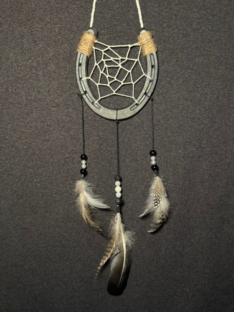 Handmade horseshoe dreamcatcher with white web, black and white beads and natural feathers